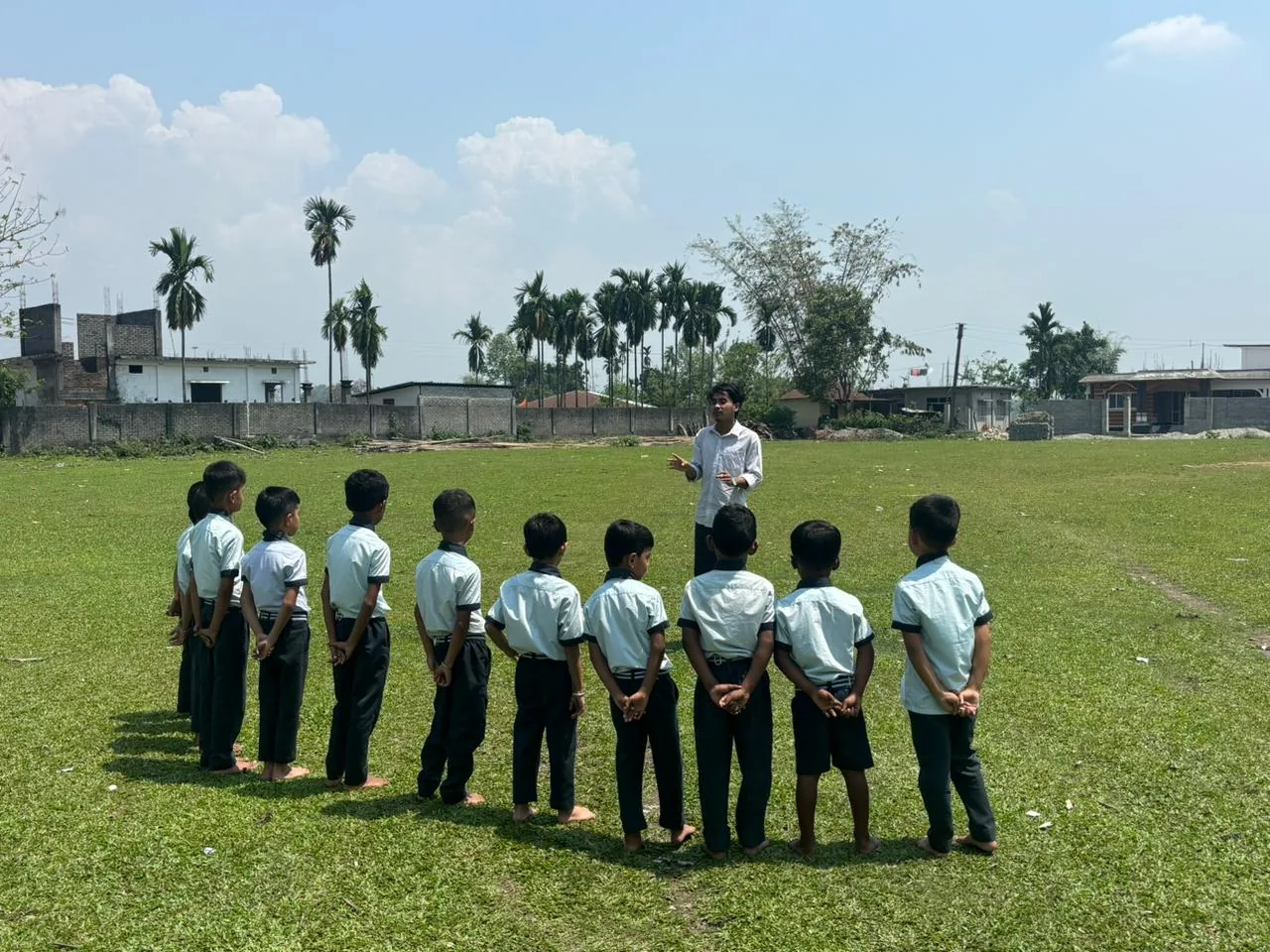 Children taking part in a physical activity on a grass playing field